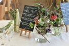Die Tischdekoration beim Essen mit Blumen und Spargel