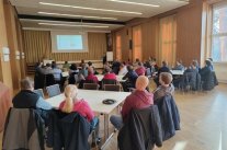 Schüler, Eltern und Lehrer bei der Zusammenkunft in der Aula