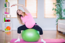 Schwangere Frau beim Training auf einem Gymnastikball