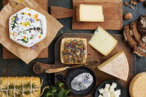Weich-, Hart-, Schnitt- und Frischkäse auf Holzbrettern angerichtet, 
