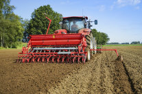 Traktor mit Sämaschine auf dem Feld 